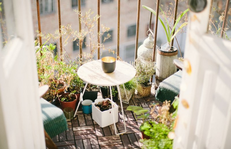 Balcón con plantas y una mesa