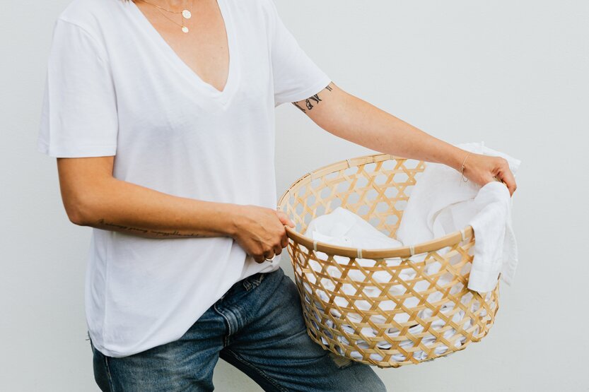 Mujer sosteniendo una cesta con ropa sucia